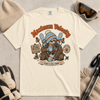 Ivory white t-shirt with a sloth graphic and 'Maximum Velocity' text, surrounded by winter accessories on a beige background.