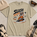 Khaki colored t-shirt with a graphic of a raccoon snowboarding and 'Slush Season' text, surrounded by winter accessories.