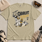 Bay green t-shirt with a graphic design featuring a dachshund snowboarder and 'Chairlift Delinquent' text, surrounded by winter accessories.