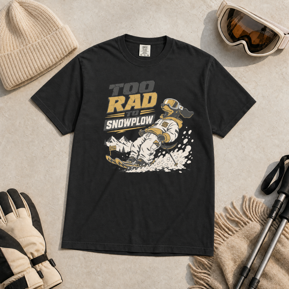 Black t-shirt with graphic design and text, surrounded by winter accessories on a light background