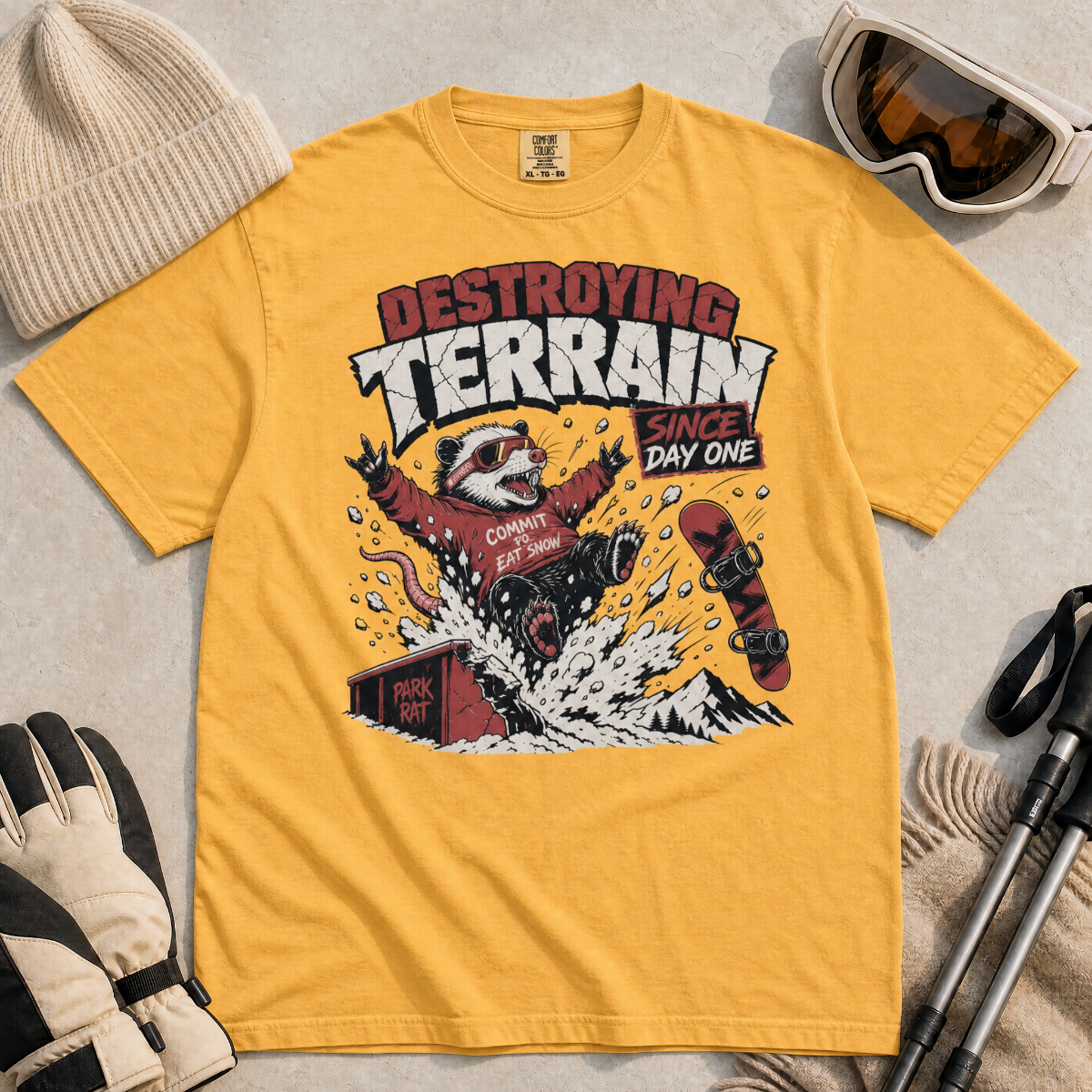 Mustard yellow t-shirt with a graphic of a snowboarding possum and text on a red background