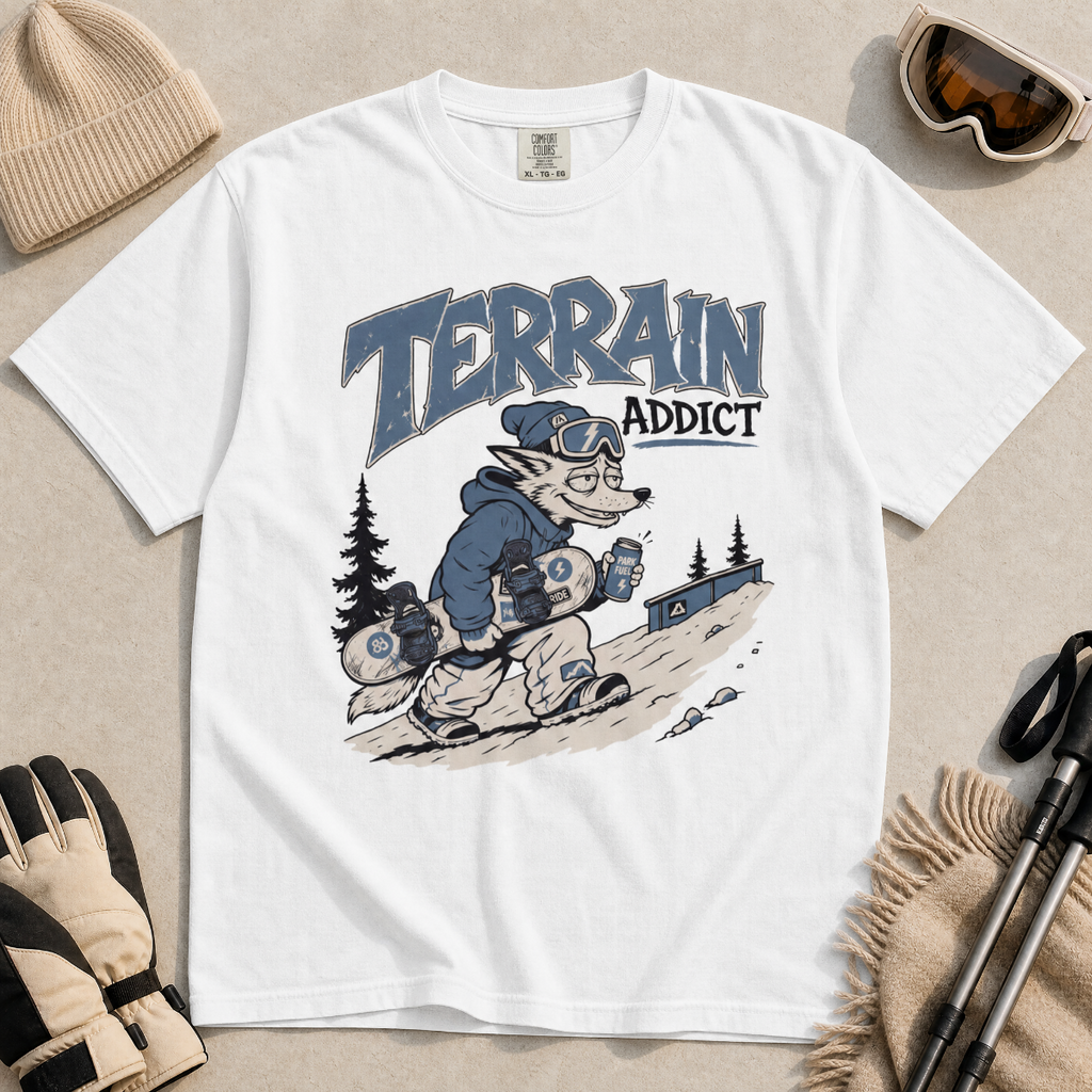 White t-shirt with 'Terrain Addict' graphic on a light gray surface with winter accessories.