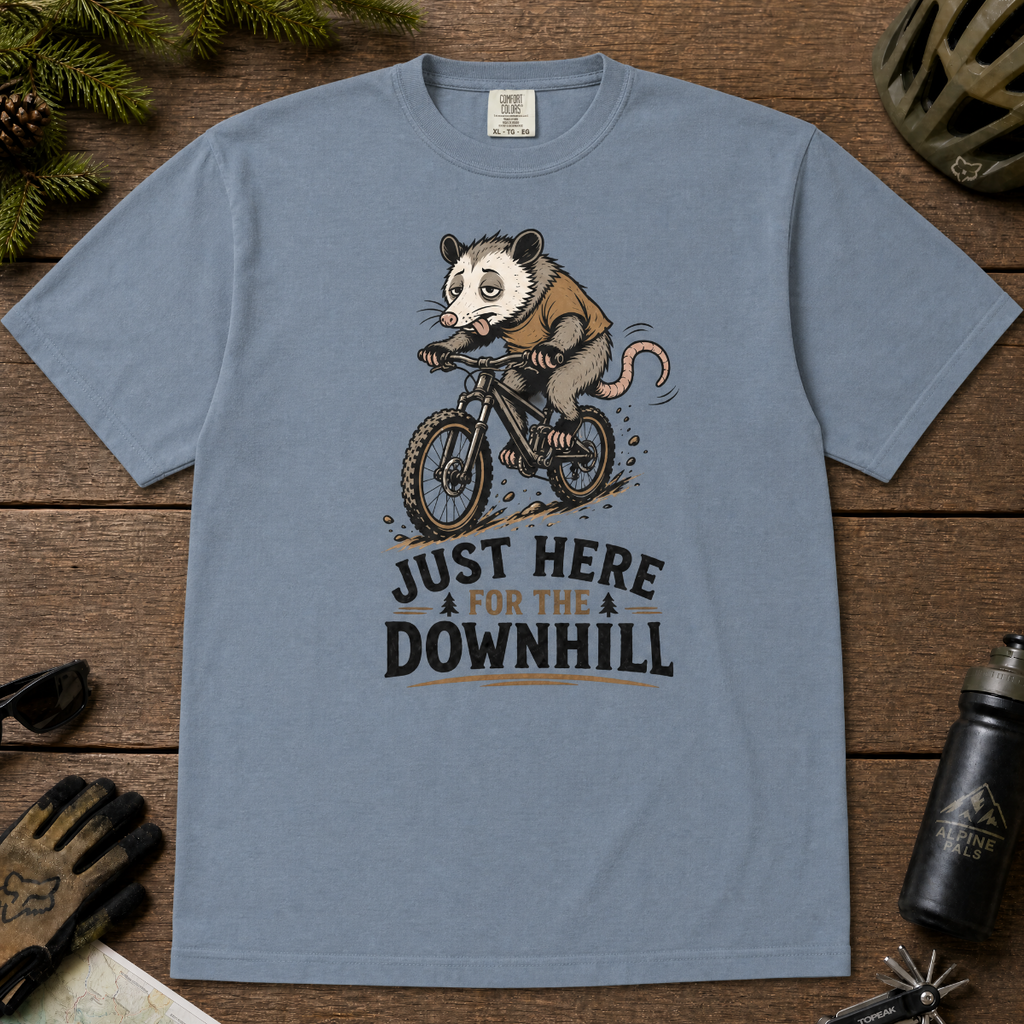 Blue jean colored t-shirt with an opossum riding a bike graphic and text 'Just Here for the Downhill'.