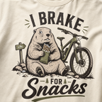Ivory white colored t-shirt with 'I Brake For Snacks' text and a marmot eating a bar with a mountain bike on the side.