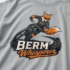 Granite gray t-shirt with a graphic of a fox riding a bike and ' Berm Whisperer'.