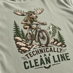 Bay green t-shirt with a graphic of a moose riding a bike and mountains, featuring the text 'Technically A Clean Line'.