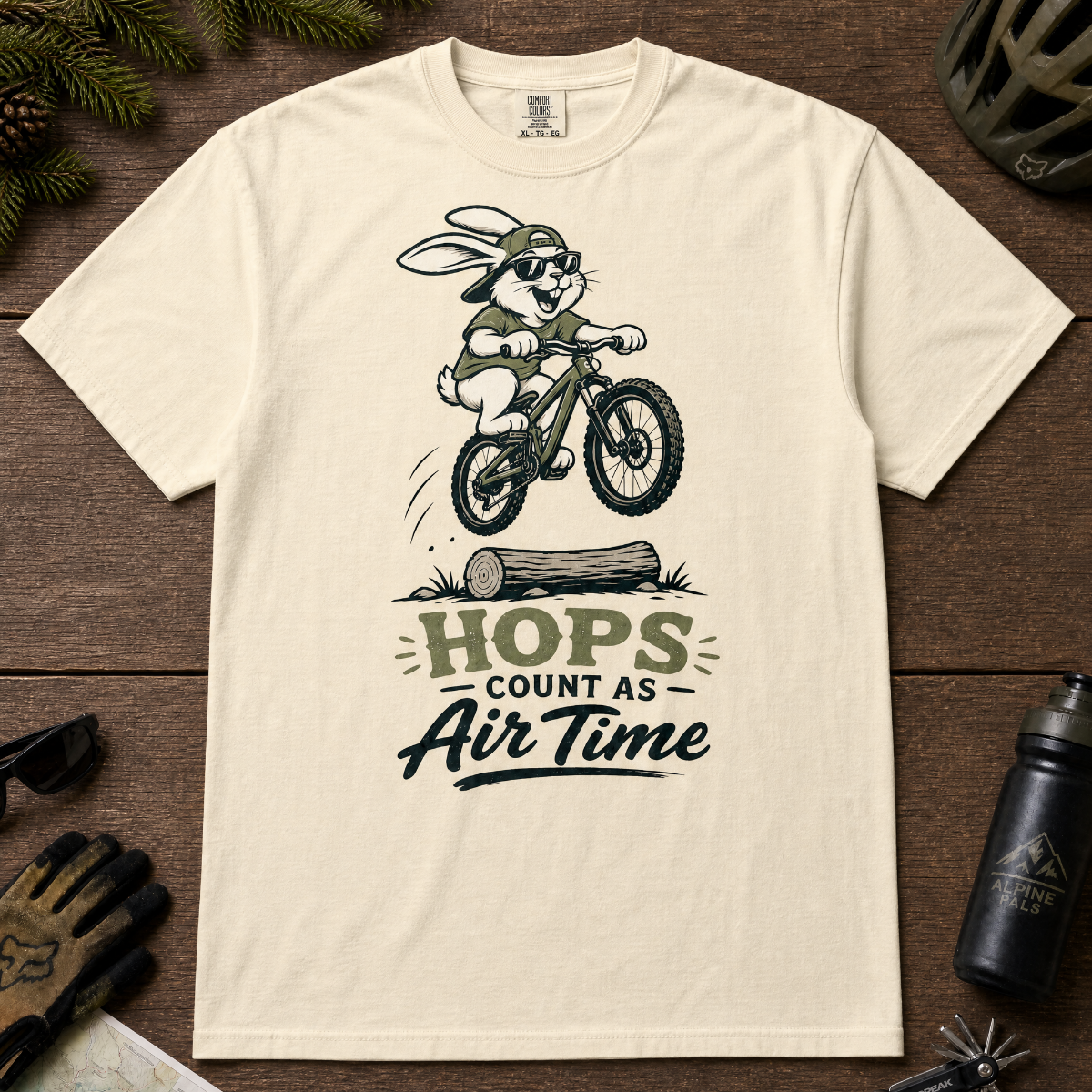 Ivory white t-shirt with a graphic of a rabbit riding a bike and text 'HOPS COUNT AS AIR TIME'.