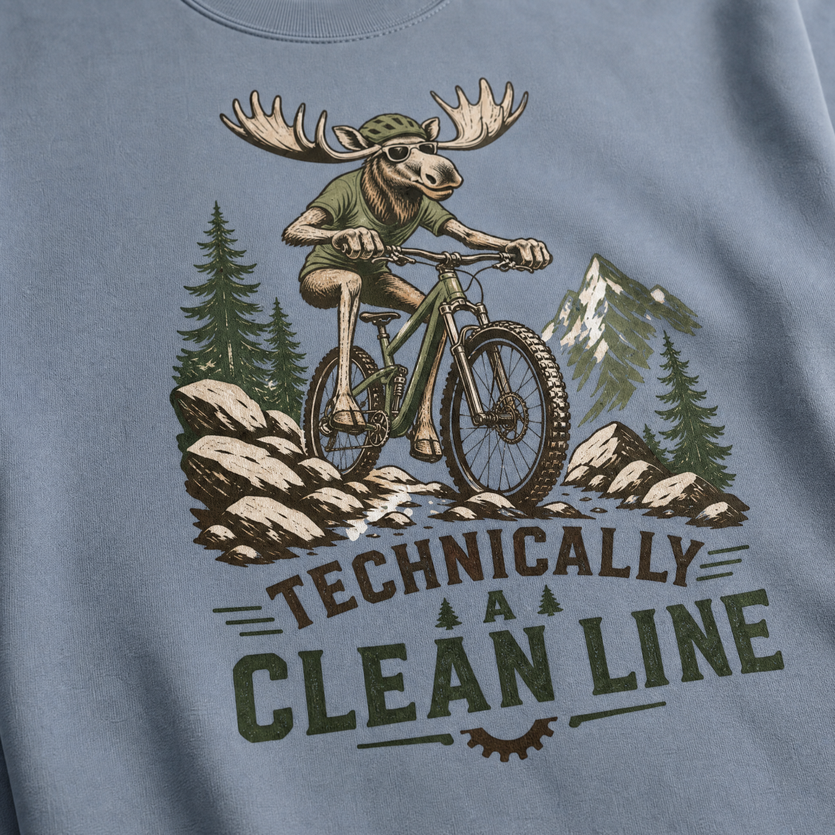 Blue jean colored t-shirt with a graphic of a moose riding a bike and text 'Technically A Clean Line'.