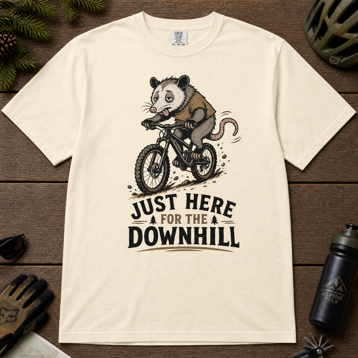 Ivory white t-shirt with an opossum riding a bike graphic and text 'Just Here for the Downhill'.