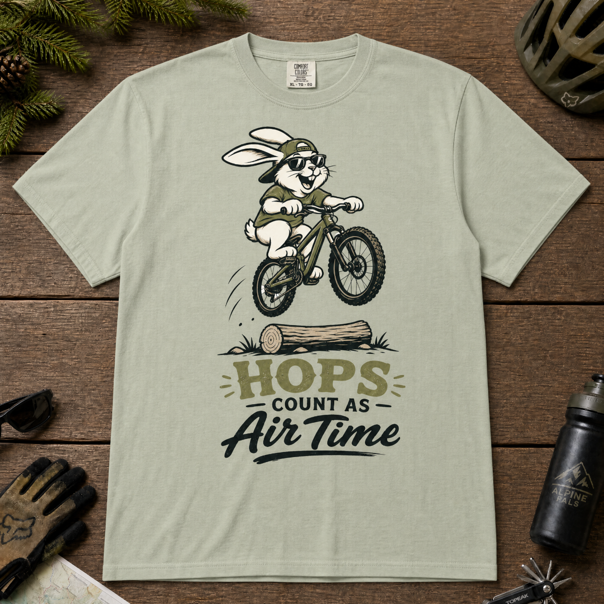 Bay green t-shirt with a graphic of a rabbit riding a bike and text 'HOPS COUNT AS AIR TIME'.