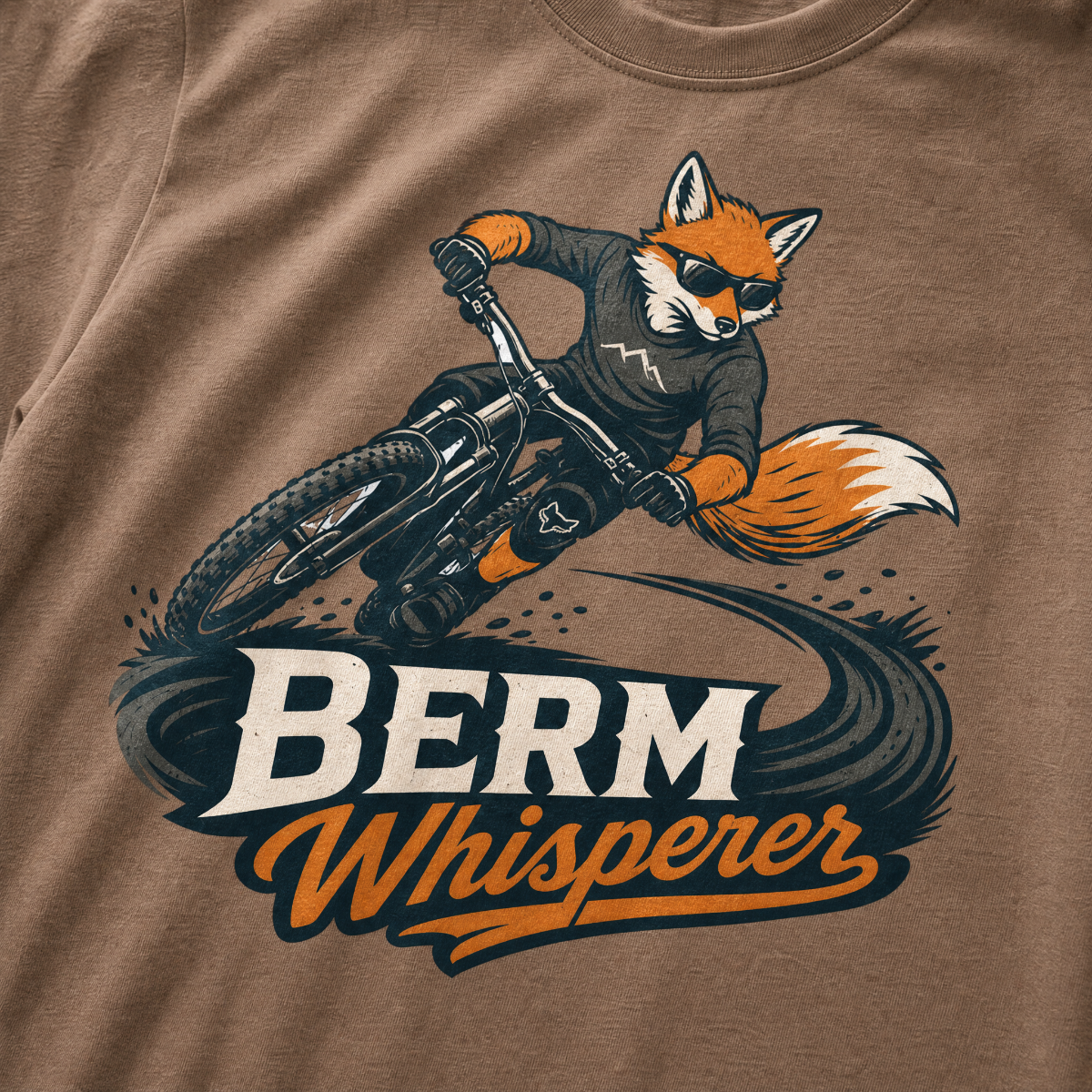 Espresso brown t-shirt with a graphic of a fox riding a bike and ' Berm Whisperer'.