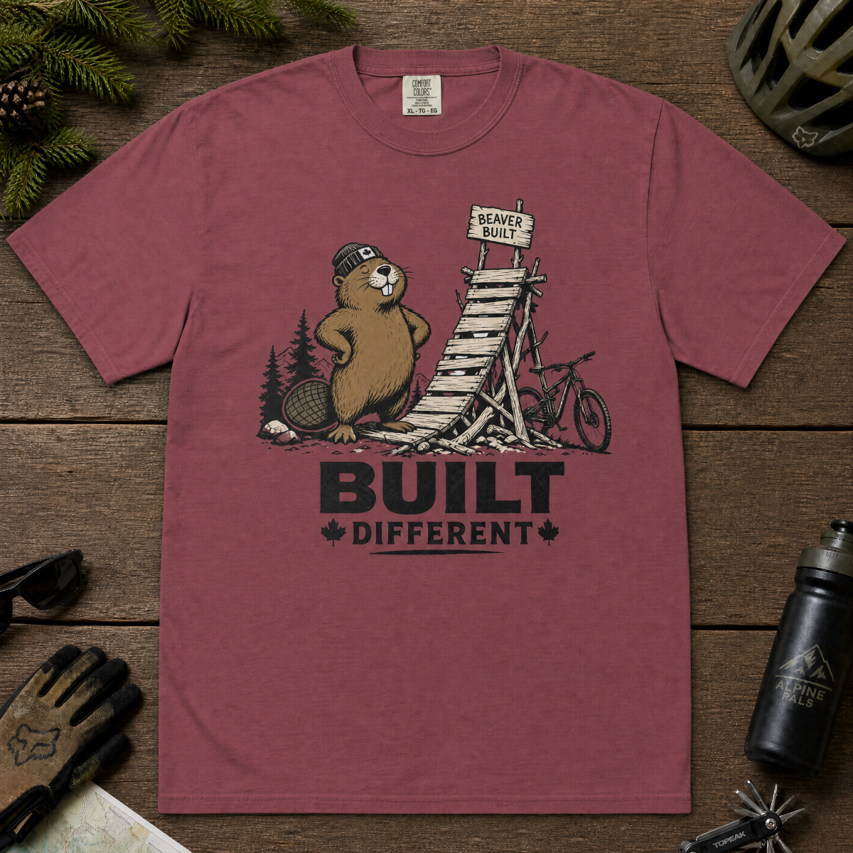 Brick red t-shirt with beaver graphic and 'Built Different' text on a white background
