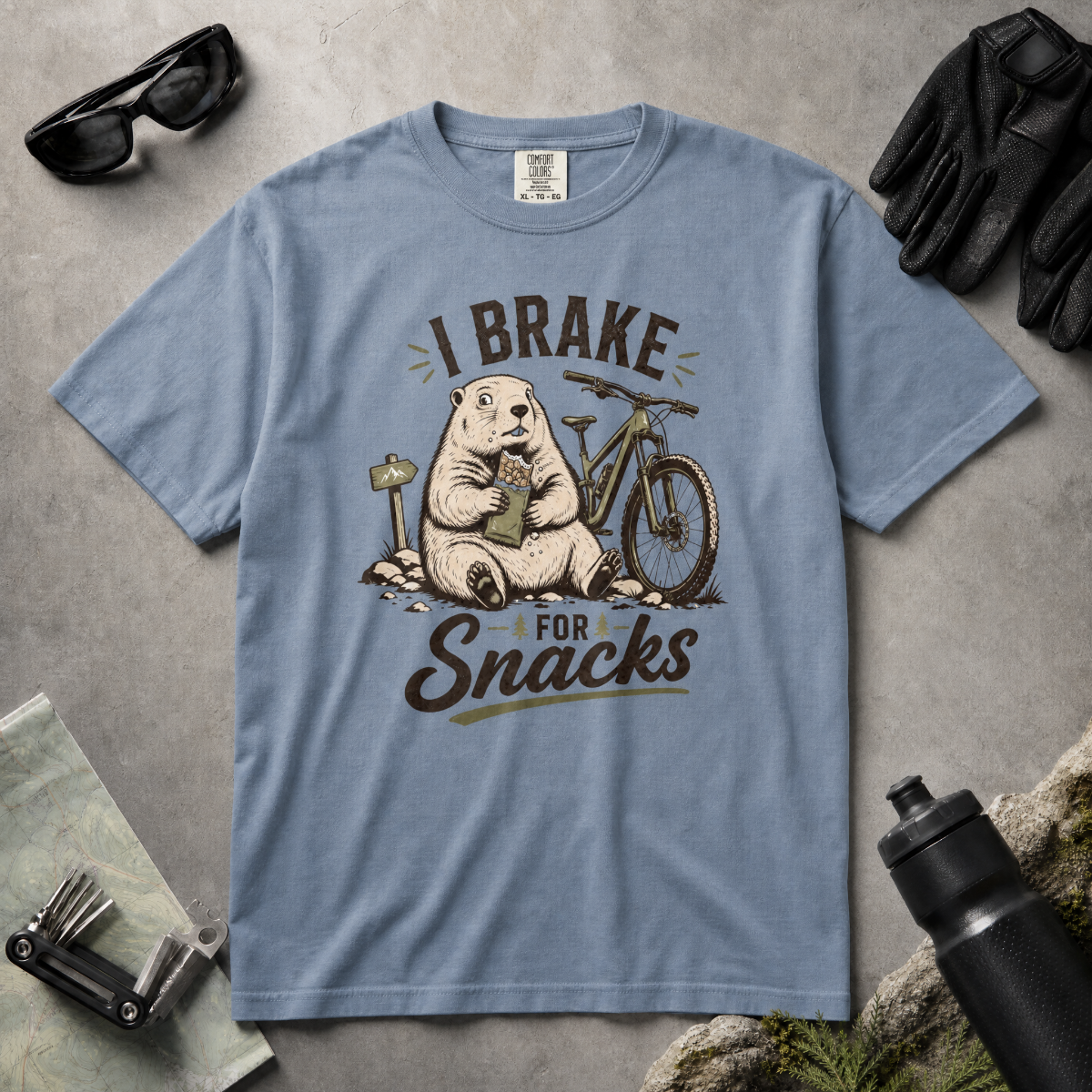 Blue jean colored t-shirt with 'I Brake For Snacks' text and a marmot eating a bar with a mountain bike on the side.