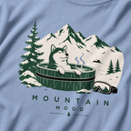 Washed denim blue t-shirt with a graphic of a husky in a hot tub surrounded by mountains and trees.