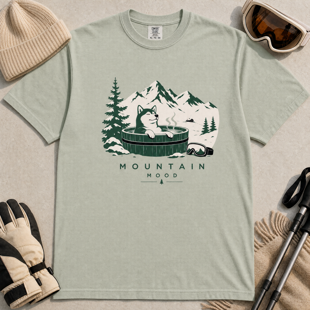 Bay green t-shirt with a graphic of a husky in a hot tub surrounded by mountains and trees.
