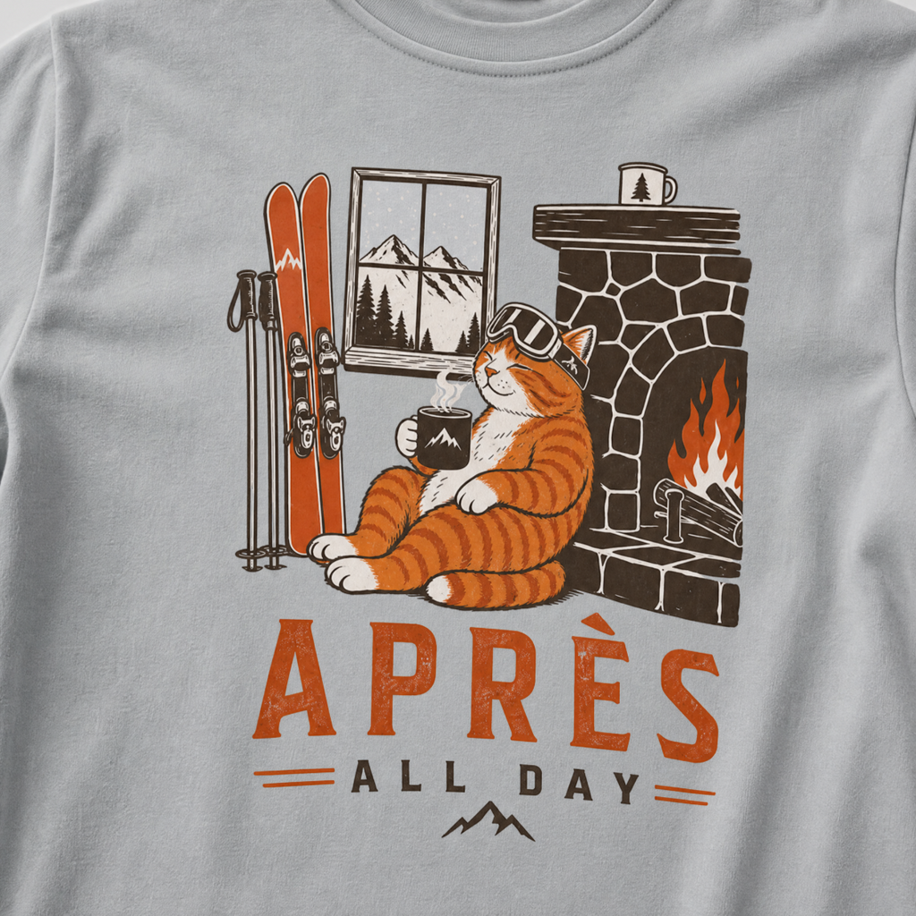 Granite gray t-shirt with a graphic of a cat by a fireplace and skis, with 'Après All Day' text.