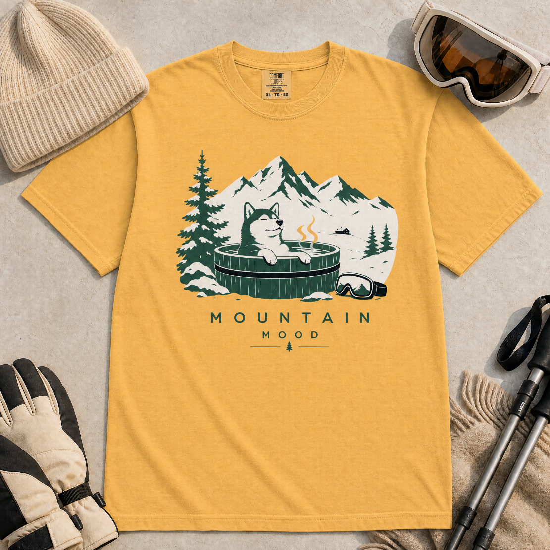 Mustard yellow t-shirt with a graphic of a husky in a hot tub surrounded by mountains and trees.