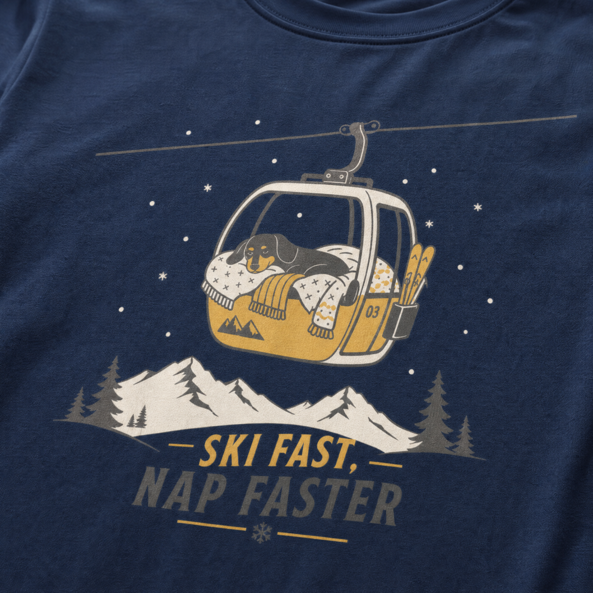 Navy blue t-shirt with a graphic of a dog in a gondola lift and text 'Ski Fast Nap Faster'.