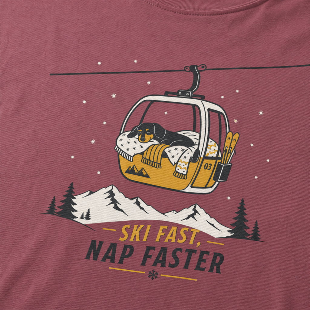 Brick red t-shirt with a graphic of a dog in a gondola lift and text 'Ski Fast Nap Faster'.