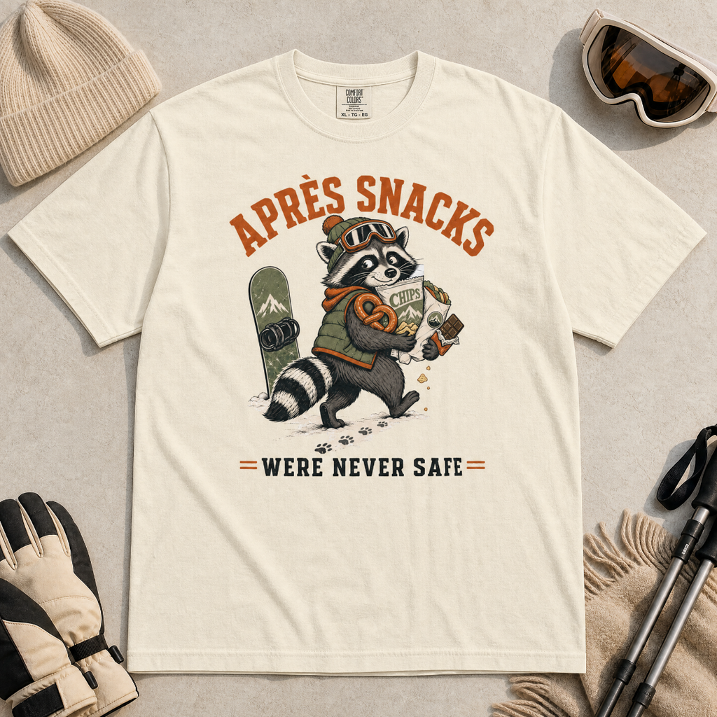 Ivory white t-shirt with a raccoon stealing snacks graphic and "Après Snacks Were Never Safe" text.