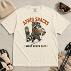 Ivory white t-shirt with a raccoon stealing snacks graphic and "Après Snacks Were Never Safe" text.