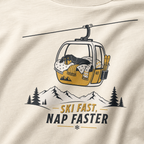 Ivory white t-shirt with a graphic of a dog in a gondola lift and text 'Ski Fast Nap Faster'.