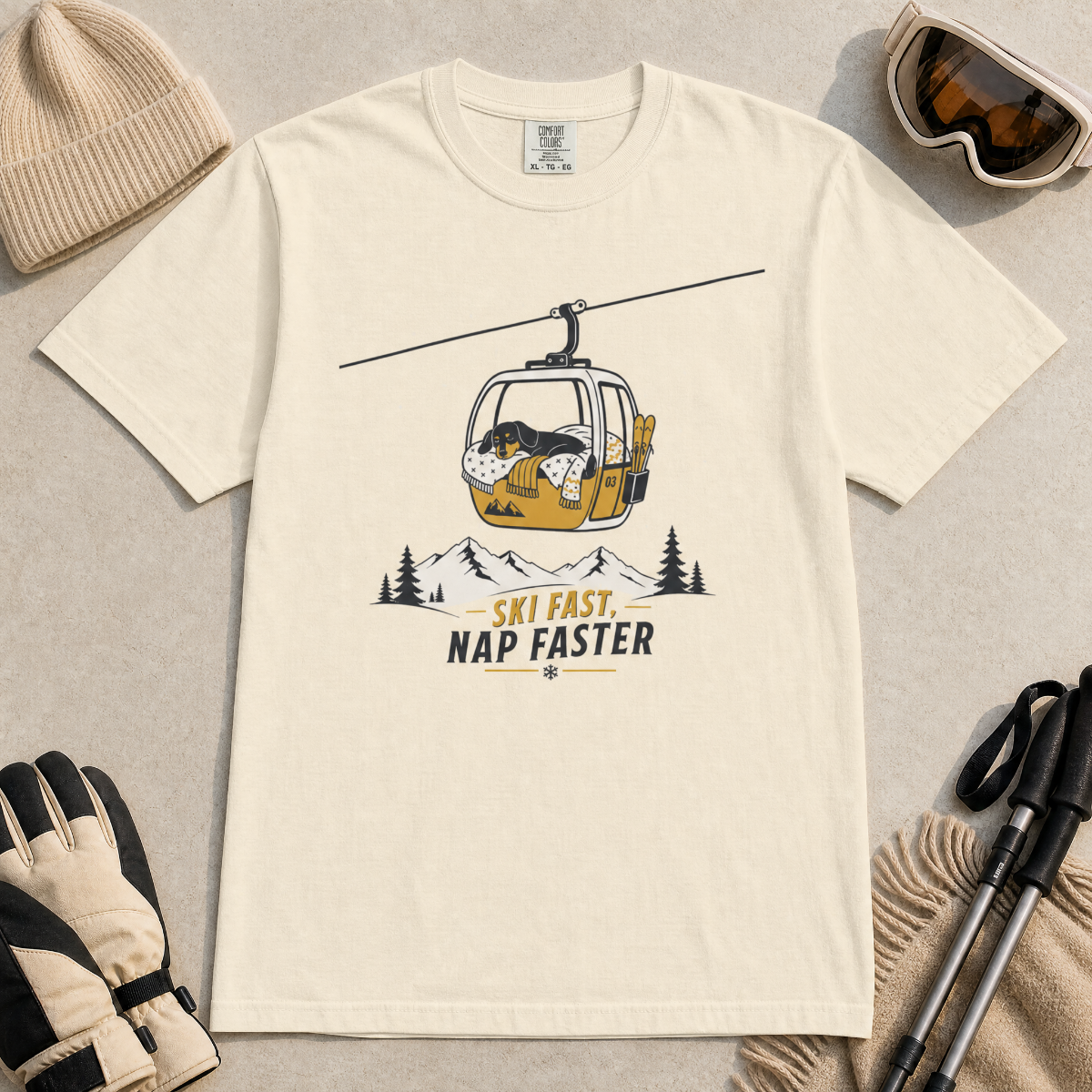 Ivory white t-shirt with a graphic of a dog in a gondola lift and text 'Ski Fast Nap Faster'.