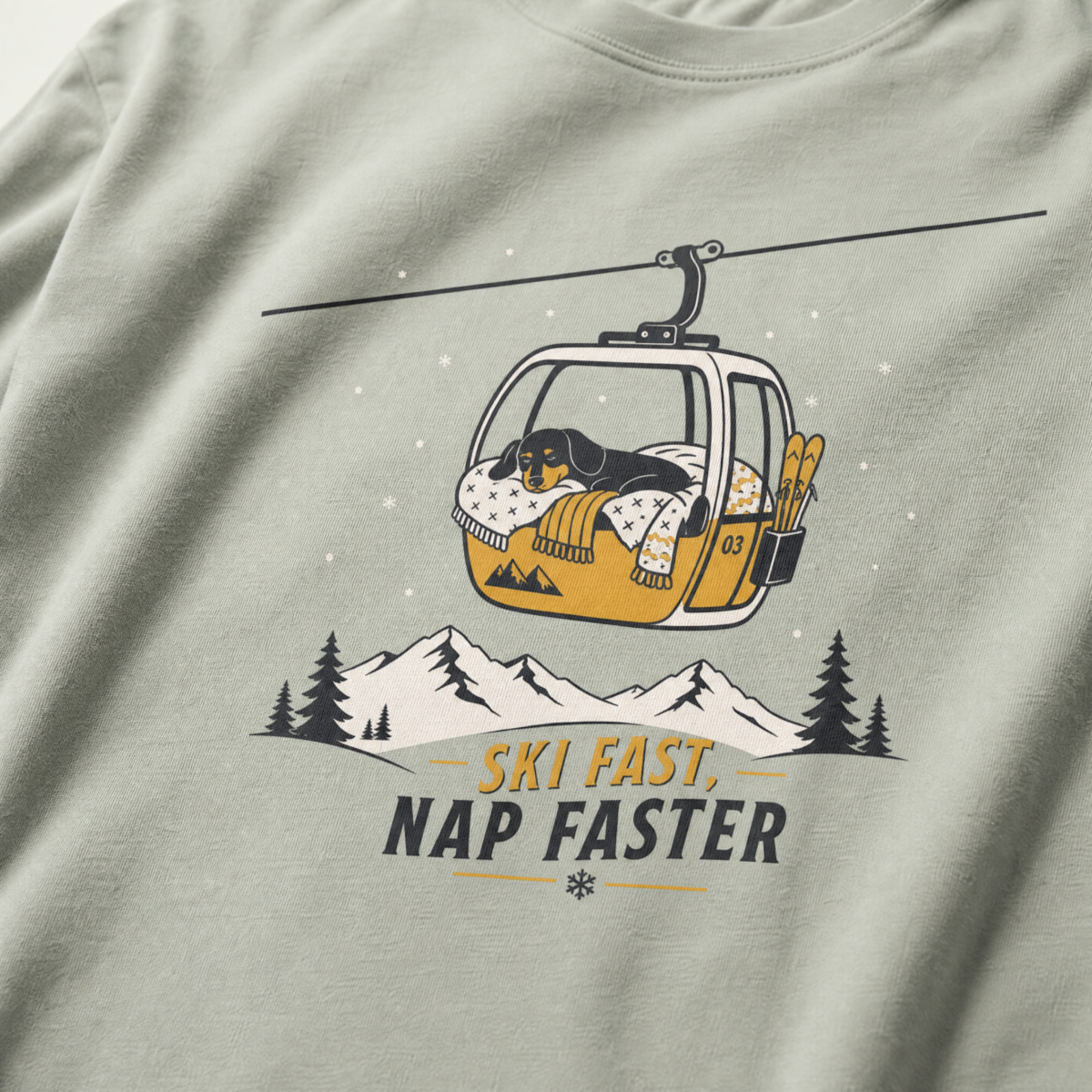 Bay green t-shirt with a graphic of a dog in a gondola lift and text 'Ski Fast Nap Faster'.