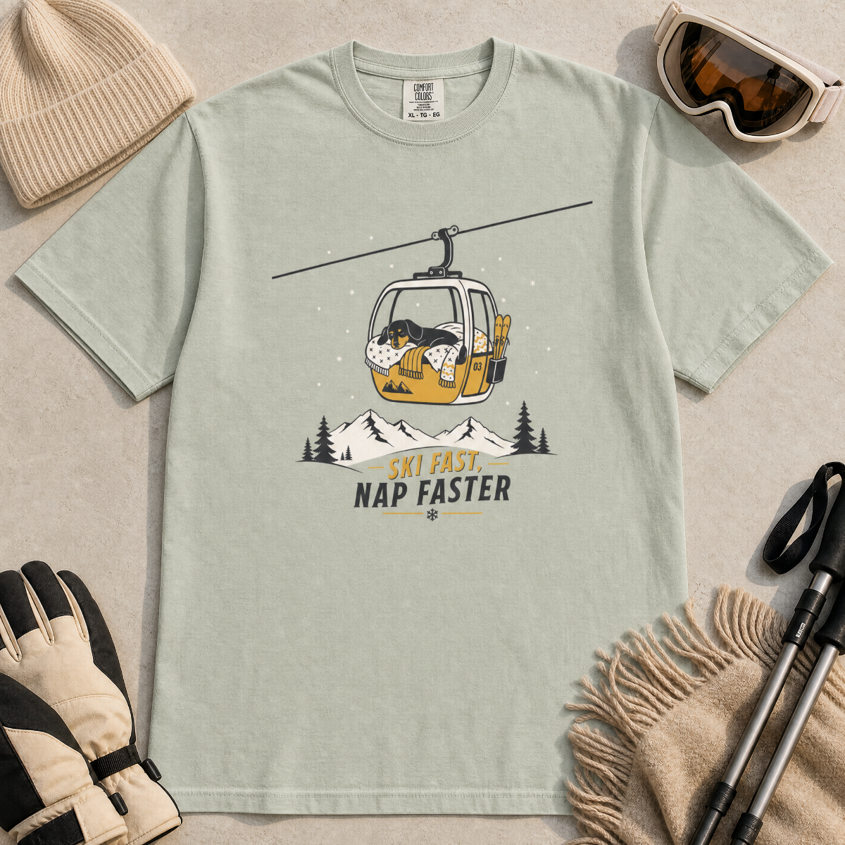 Bay green t-shirt with a graphic of a dog in a gondola lift and text 'Ski Fast Nap Faster'.