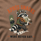 Espresso brown t-shirt with a raccoon stealing snacks graphic and "Après Snacks Were Never Safe" text.