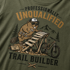 Hemp green t-shirt with a beaver graphic and text 'Professionally Unqualified Trail Builder' on a mountainous background.