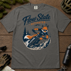 Pepper gray t-shirt with a fox riding a bike graphic and 'Flow State Activated' text on a wooden surface.