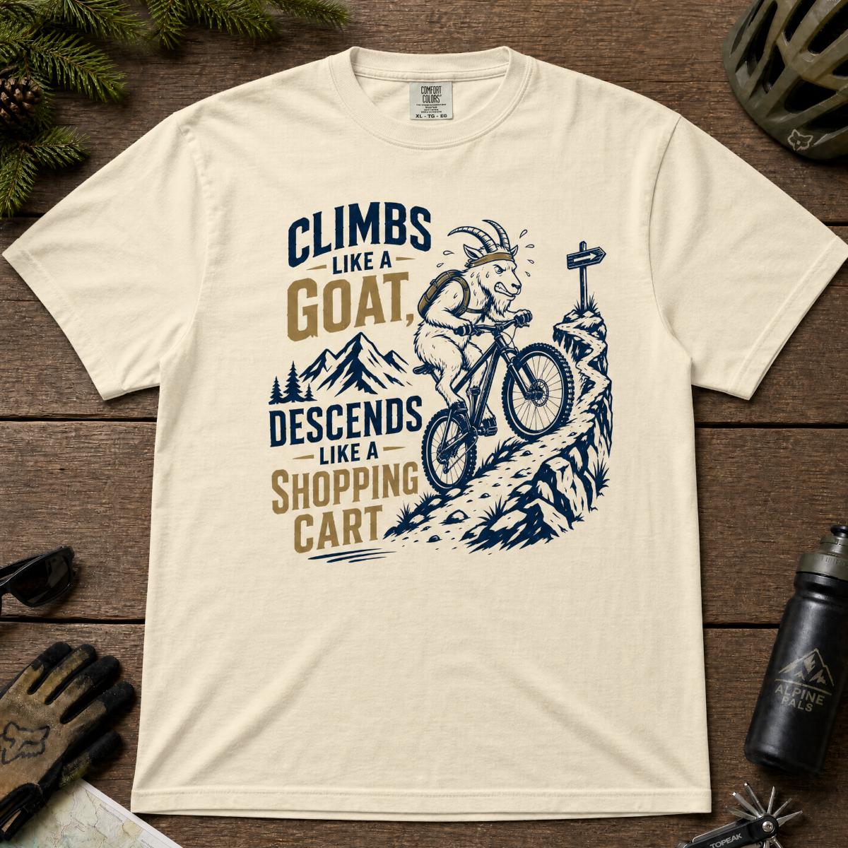 Ivory white t-shirt with graphic design and text on a wooden surface with outdoor gear.