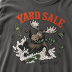 Pepper gray t-shirt with moose graphic and 'Yard Sale' text, surrounded by winter accessories on a light background