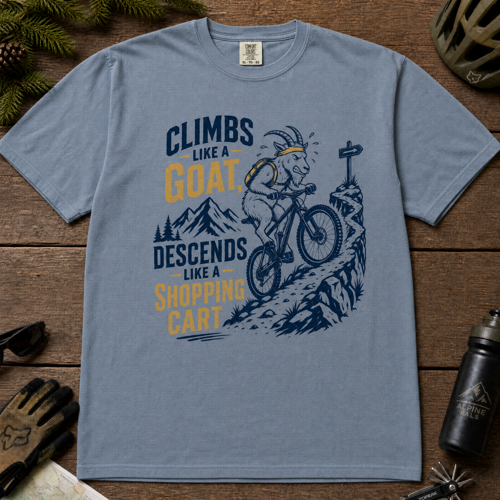 Blue jean t-shirt with graphic design and text on a wooden surface with outdoor gear.