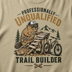Khaki colored t-shirt with a graphic of a beaver building a trail and text 'Professionally Unqualified Trail Builder'.
