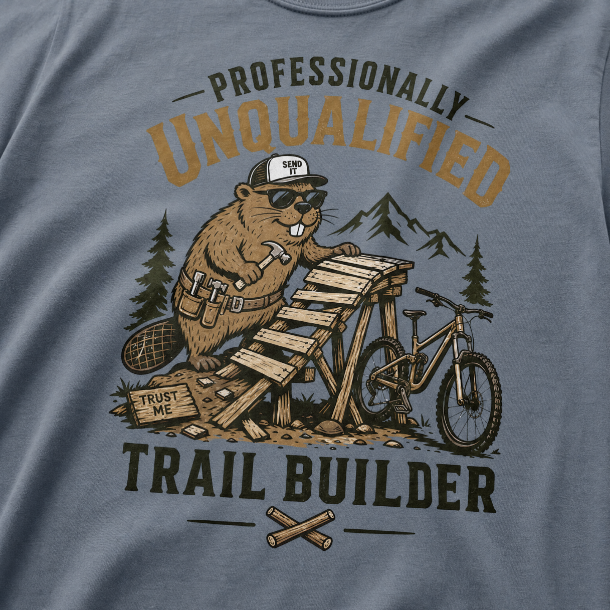 Blue jean colored t-shirt with a beaver graphic and text 'Professionally Unqualified Trail Builder'