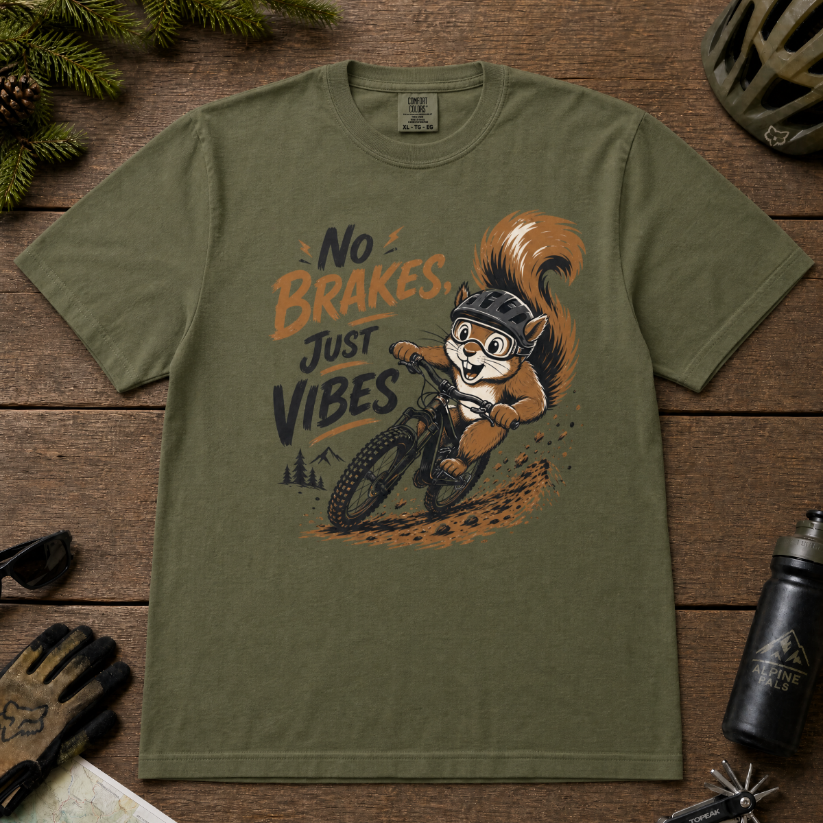 Hemp green t-shirt with a graphic of a squirrel riding a bike and text 'No Brakes, Just Vibes' on a wooden surface.