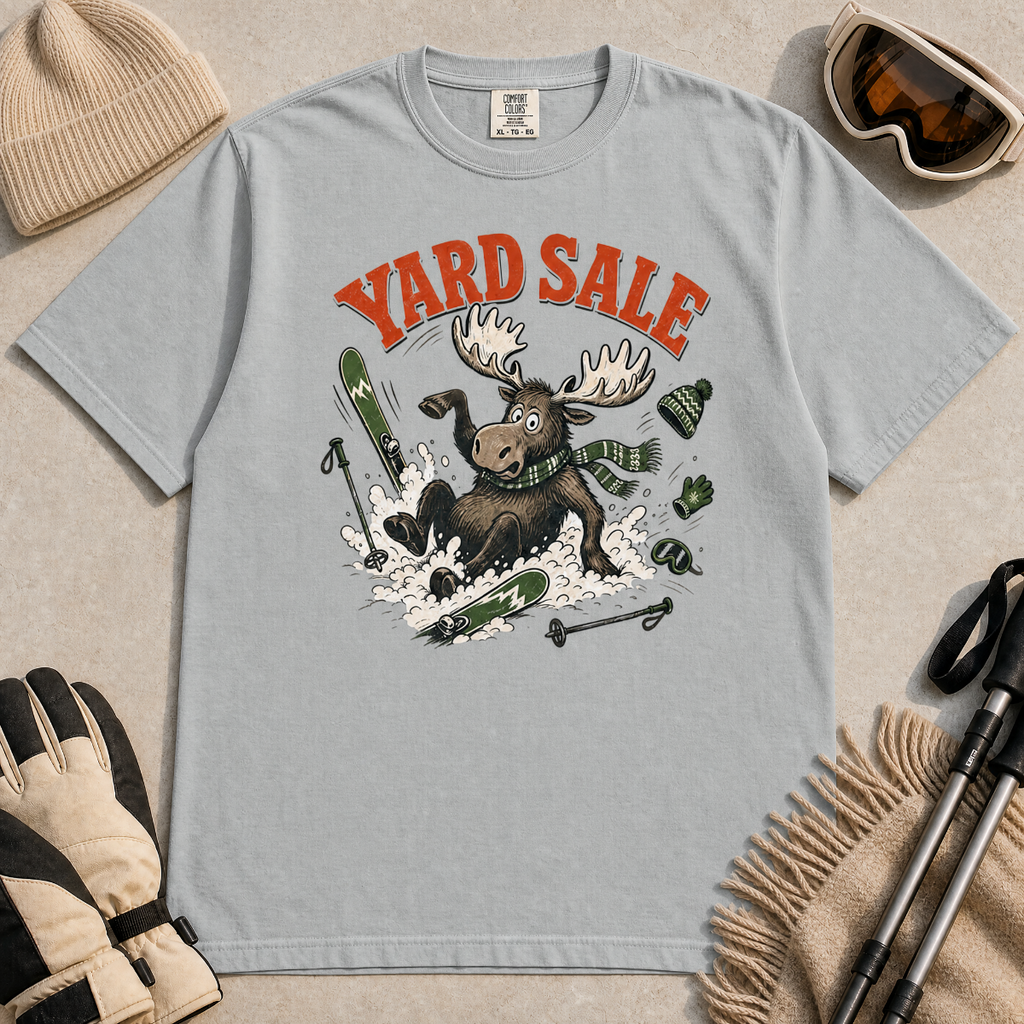 Granite gray t-shirt with moose graphic and 'Yard Sale' text, surrounded by winter accessories on a light background