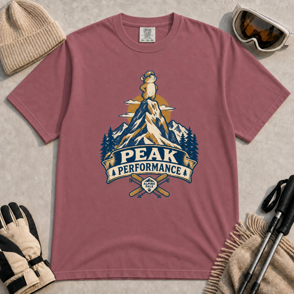 Brick t-shirt featuring a retro “Peak Performance” ski graphic with a goggle-wearing marmot standing atop a snowy mountain above crossed skis.