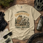 Beige t-shirt with bear graphic and text on a wooden surface with outdoor gear.