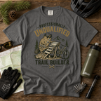 Gray t-shirt with a beaver graphic and text on a wooden surface with outdoor gear.