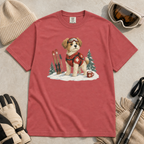 Flat lay of a crimson red t-shirt featuring a cute ski patrol dog design with red rescue gear, skis, snowy trees, and a hot cocoa mug.