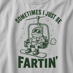 Close-up of a granite gray t-shirt with a playful frog chairlift graphic and bold “Sometimes I Just Be Fartin’” text.