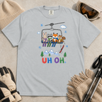 Flat lay of a granite gray t-shirt featuring a playful hand-drawn chairlift scene with bunny, raccoon, fox, and squirrel skiers, snowy mountains, and “UH OH.” text.