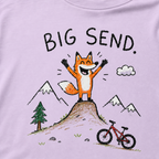 Close-up of an orchid t-shirt with a childlike crayon-style mountain biking design showing a joyful fox standing on a dirt jump with “Big Send.” text.