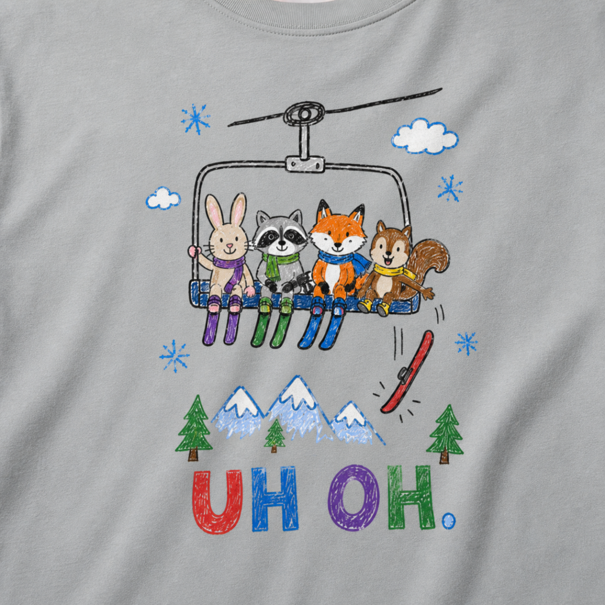 Close-up of a granite gray t-shirt with a childlike crayon-style ski design showing four animals on a chairlift, a loose red ski falling below, and colorful “UH OH.” text.