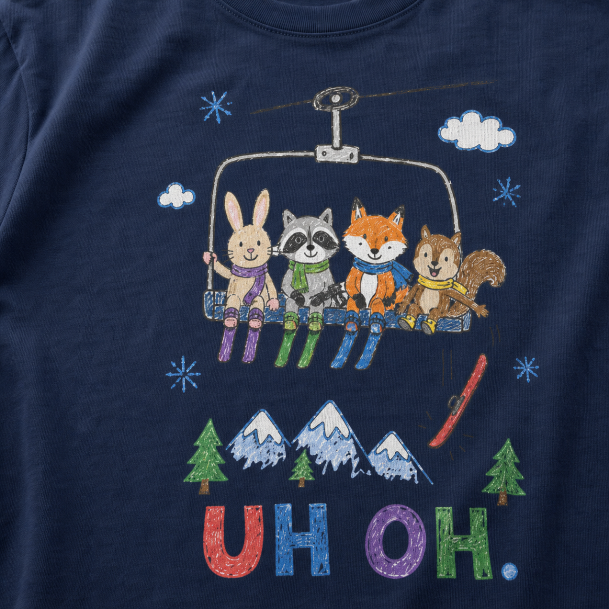 Close-up of a navy t-shirt with a childlike crayon-style ski design showing four animals on a chairlift, a loose red ski falling below, and colorful “UH OH.” text.