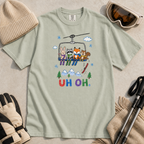 Flat lay of a bay green t-shirt featuring a playful hand-drawn chairlift scene with bunny, raccoon, fox, and squirrel skiers, snowy mountains, and “UH OH.” text.
