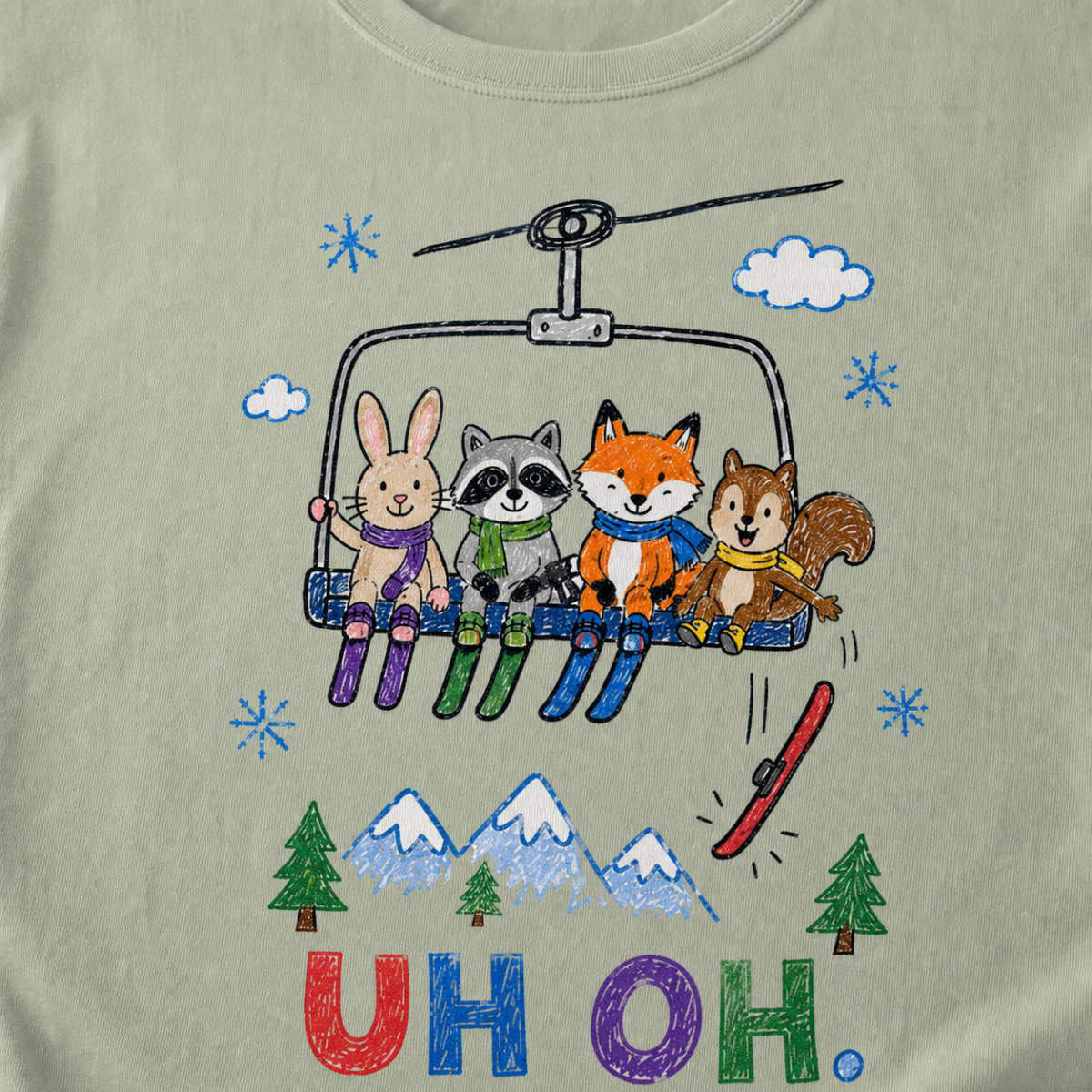 Close-up of a bay green t-shirt with a childlike crayon-style ski design showing four animals on a chairlift, a loose red ski falling below, and colorful “UH OH.” text.
